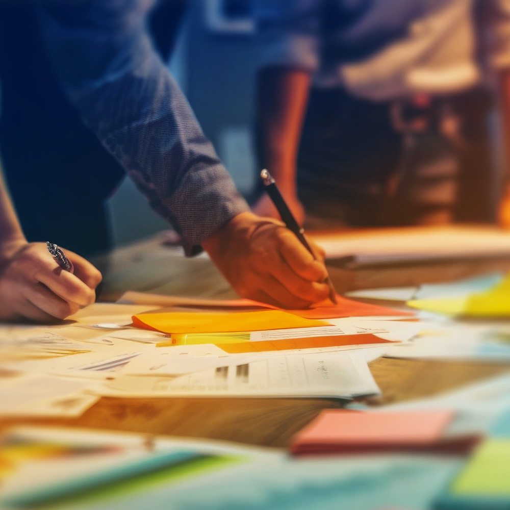Colleagues marking up plans and sticky notes around a table
